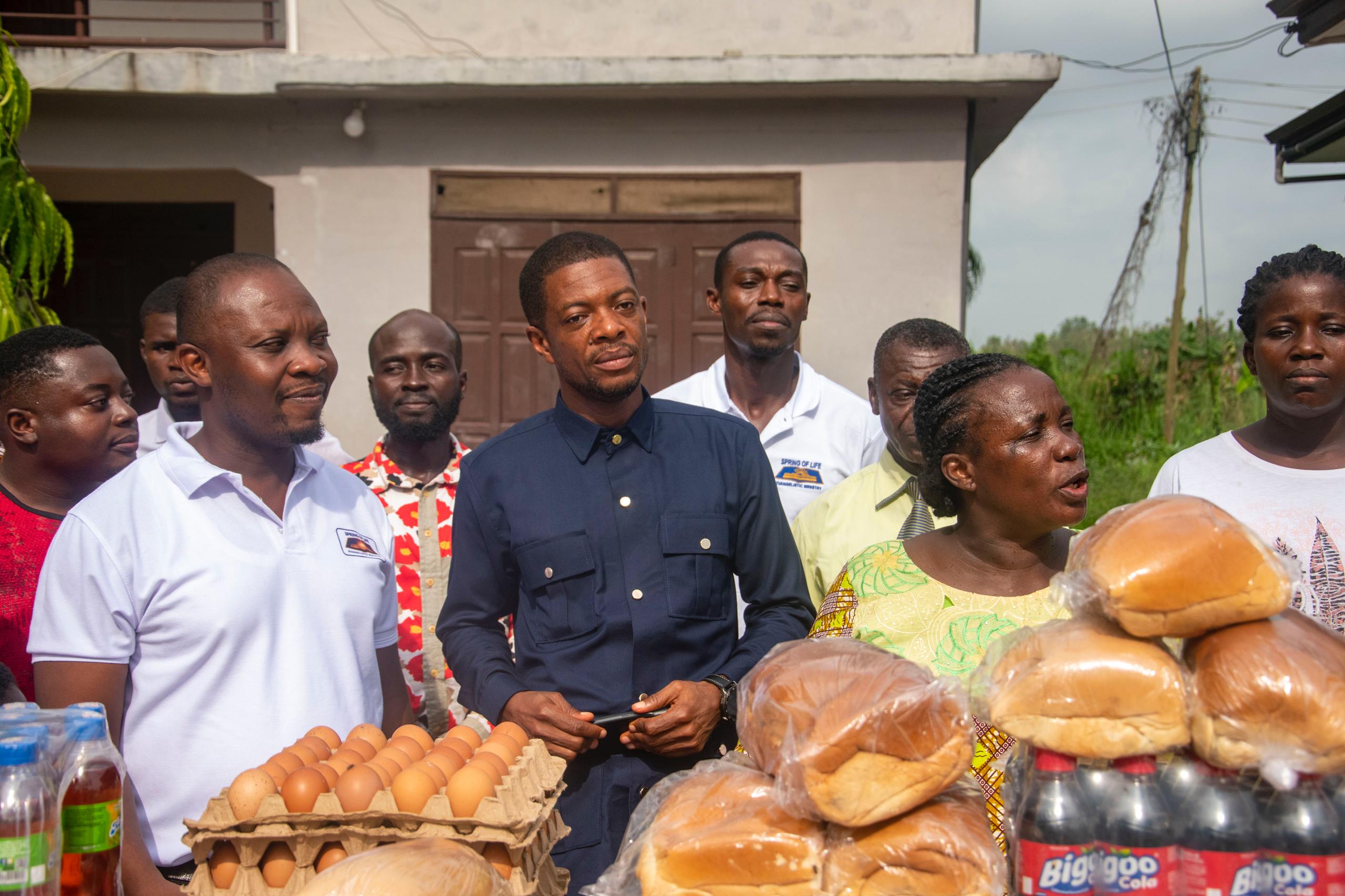 The team presenting bread, eggs and drinks during an orphanage visit
