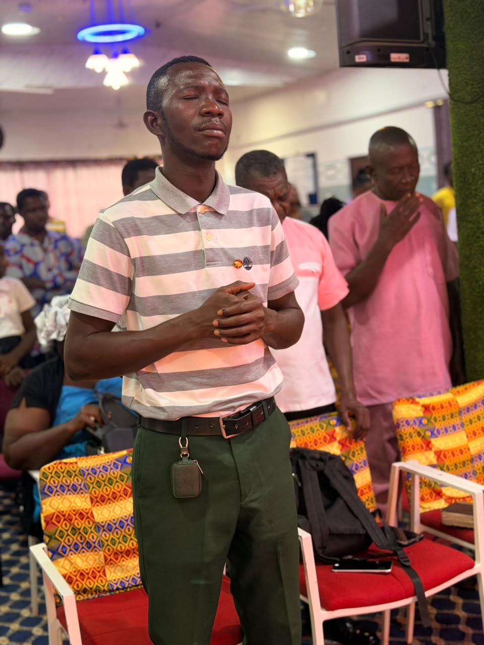 A member standing in quiet personal prayer during service
