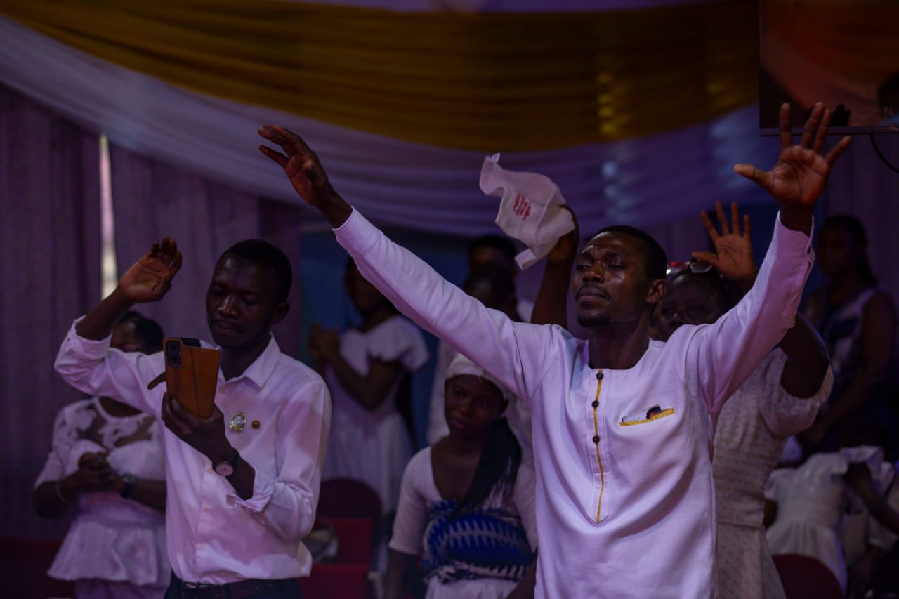 Members of Spring of Life worshipping with raised hands